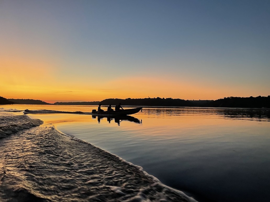 silhouette of people on canoe at sunset